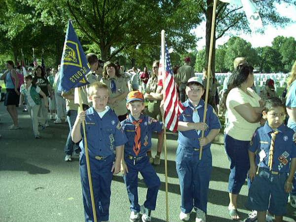 Cubs from Pack 97 proudly hold the flags.
